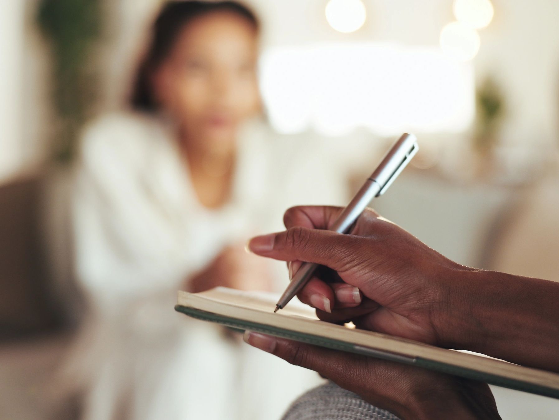 Therapist wirting on notepad during therapy session.