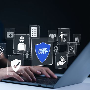 Hands typing on a laptop with floating work safety icons.