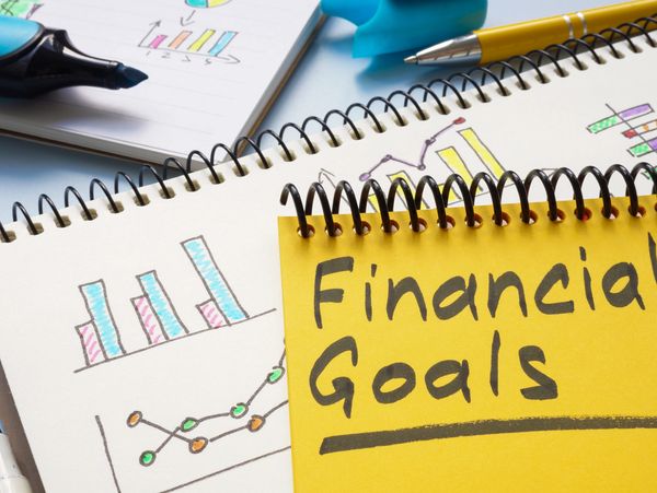 Notebooks with financial goals and colorful charts.