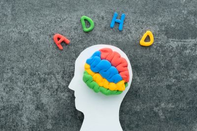 ADHD concept with colorful brain model inside a human head silhouette.