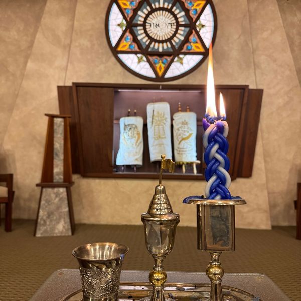 Three trophies with a candle burning above them