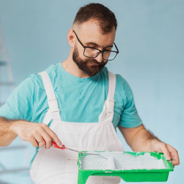 Painter preparing green paint tray.