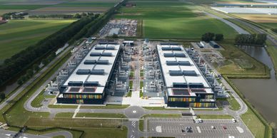 Aerial view of a large industrial complex surrounded by green fields and waterways.