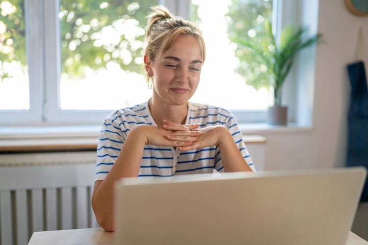 Stack of books next to pencils in a holder and a camera.