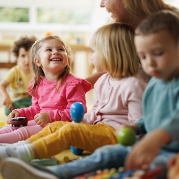 Happy children playing and interacting together in a classroom.