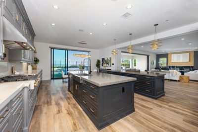 A modern high-end kitchen with marble countertop, wood cabinets, wood flooring in Deerfield Beach