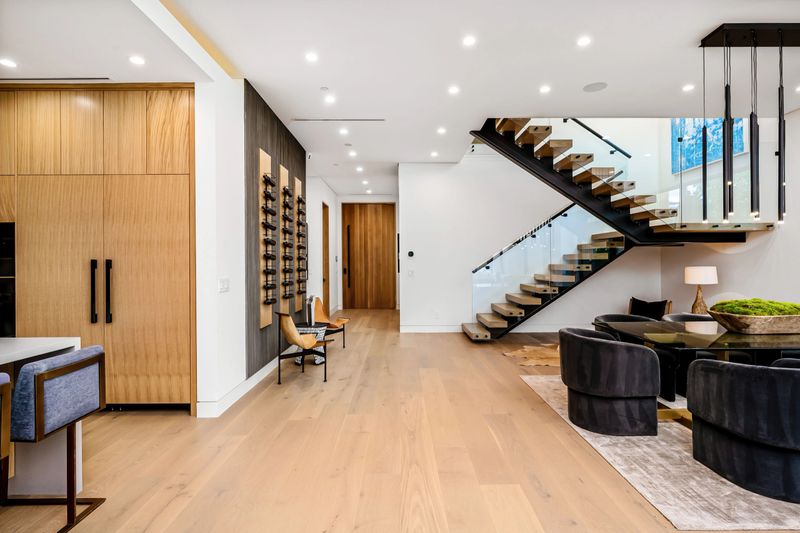 Modern interior of a luxury home with open space living area, wooden flooring, and a stylish staircase.