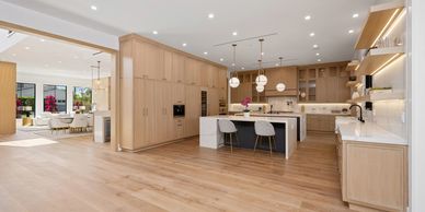 Spacious modern kitchen with light wood cabinetry and island seating.