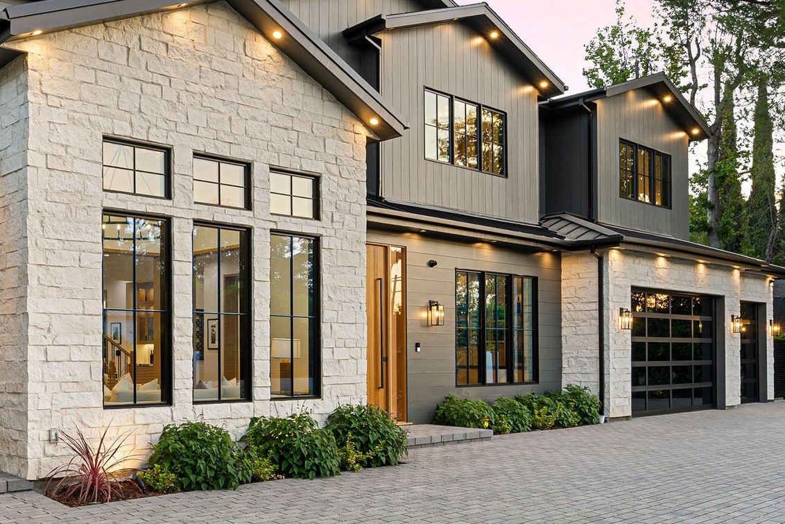 Modern two-story house exterior with stone and wood accents.