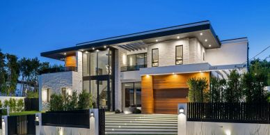 Modern luxury house with sleek design and illuminated exterior at dusk.
