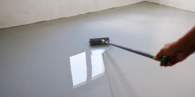 Applying a smooth epoxy coating on the floor.