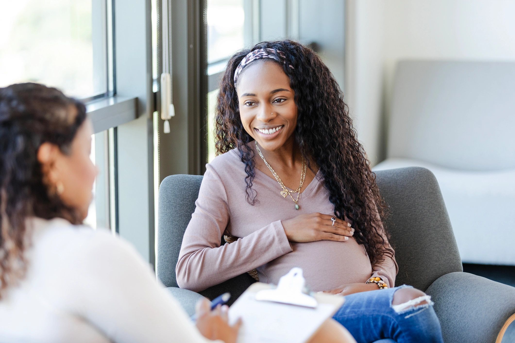 Pregnant woman smiling during a counseling session.