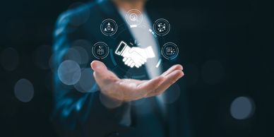 Businessman presenting digital handshake icon symbolizing partnership and collaboration.