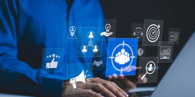 Person using laptop with digital marketing and customer targeting icons floating.