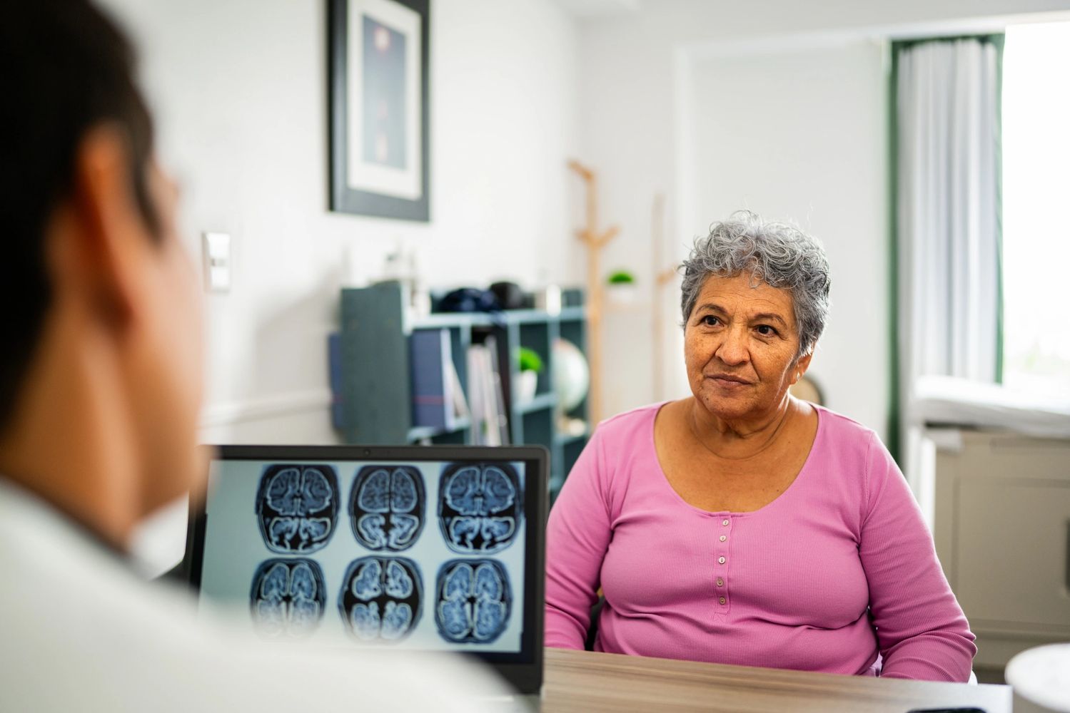 Neurologist reviewing brain imaging with an older patient during a neurological consultation.