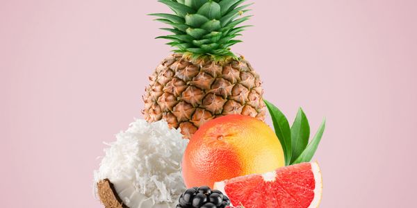 Fresh tropical fruits including pineapple, grapefruit, coconut, and blackberries.
