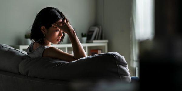 Sad woman sitting alone on a couch.