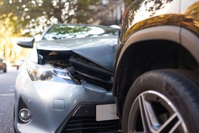 Close-up of a car accident showing front-end damage on one vehicle.