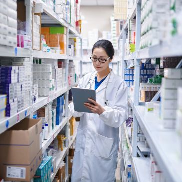 Female pharmacist checks inventory in a pharmacy.