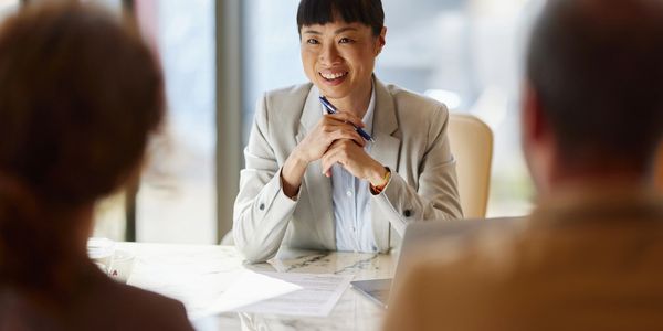 Smiling woman in business attire during a meeting.