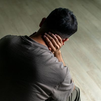 Man sitting with head in hands, appearing stressed or tired.