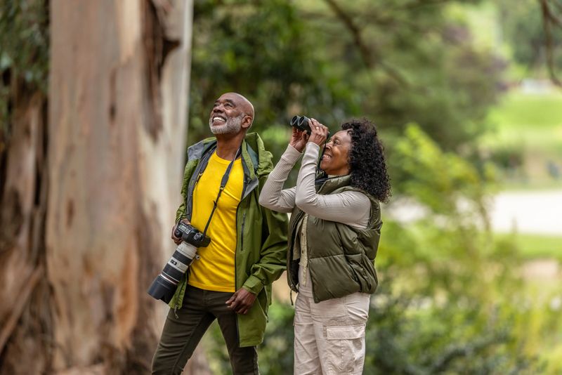 African American couple on a outdoor walk and hike enjoying bird watching and photography.