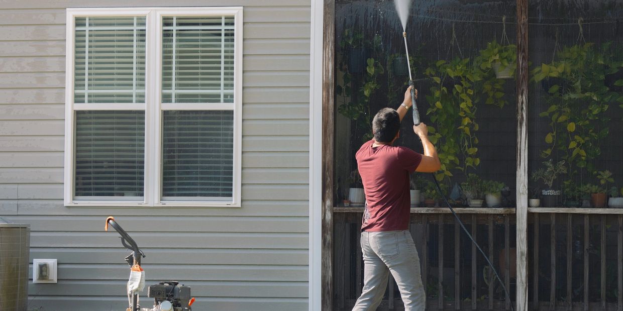 a man pressure washing a roof
