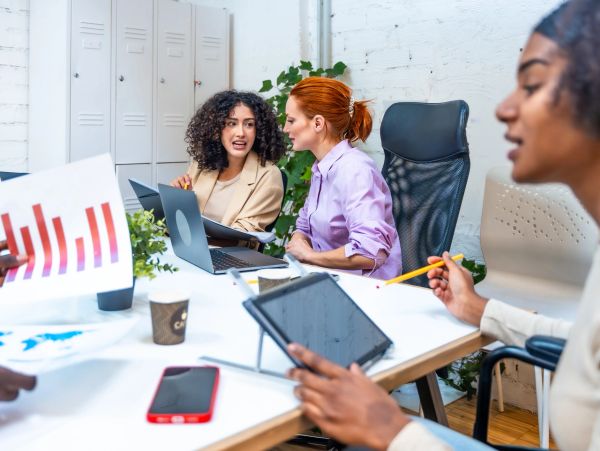 Colleagues engaging in a discussion around a table in an office.