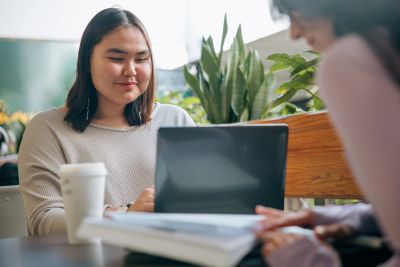 Two people working together with a laptop and documents.