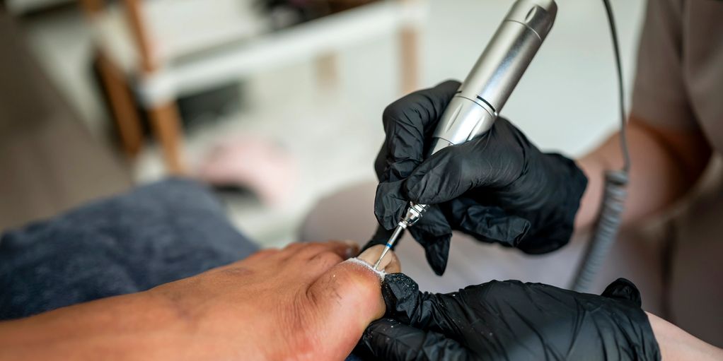 Soins des pieds professionnels avec outil électrique.