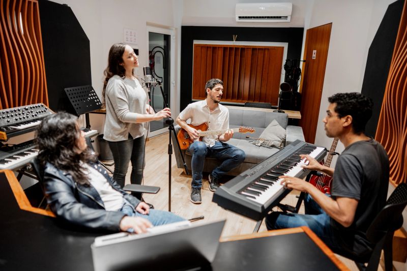 Musicians singing and playing at music studio