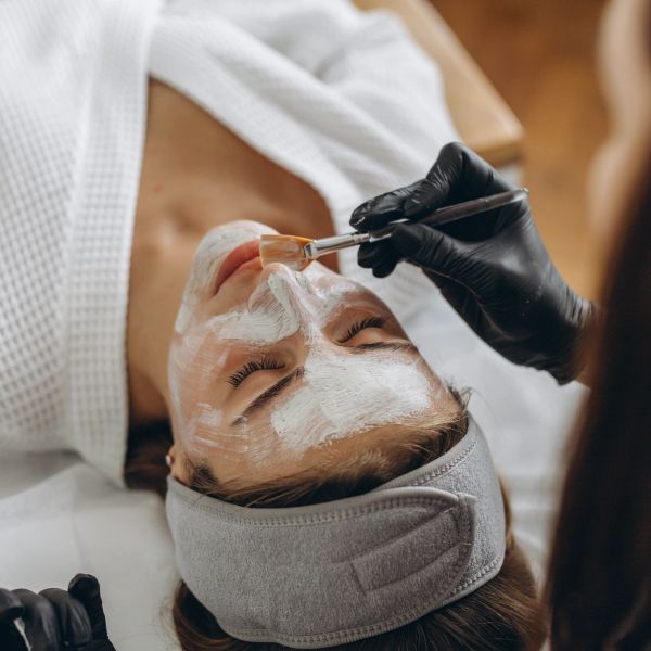 Woman getting a facial mask treatment.