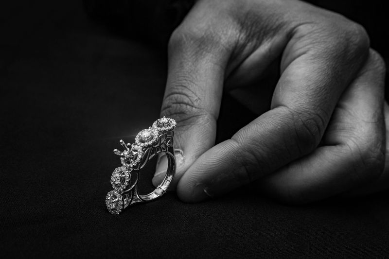 A breathtaking diamond cluster ring set against a luxurious black velvet background. This intricate piece features a large central diamond surrounded by smaller sparkling stones, crafted in a halo style, making it a perfect choice for special occasions and high-end fashion events.