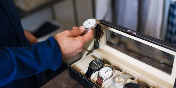 A man examining his watch collection.