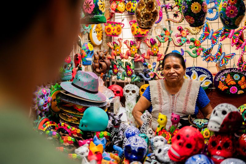 Senior woman selling day of the dead decoration at market