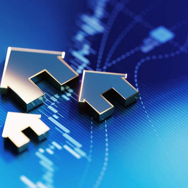 Three metallic house icons on a digital blue background.