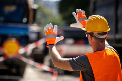 man guiding a lorry using hand signals to ensure safety 