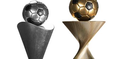 Two modern trophies with metallic soccer balls on top, one silver and one gold.