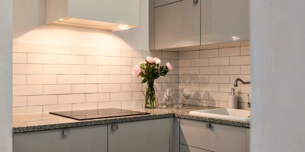 Cocina moderna con encimera gris y flores.
