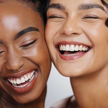 Two women smiling closely together.