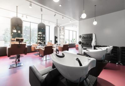 Modern hair salon with styling chairs and washing stations.