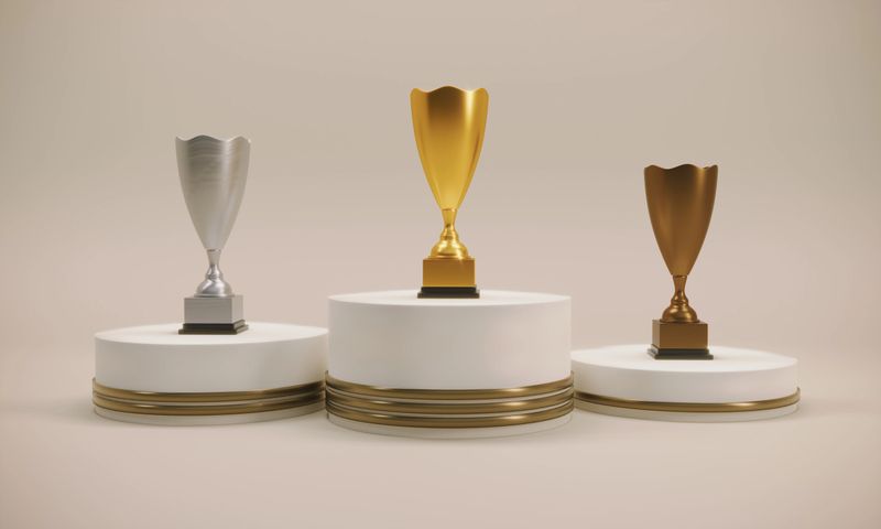 Award podium with gold, silver and bronze trophies. (3d render)