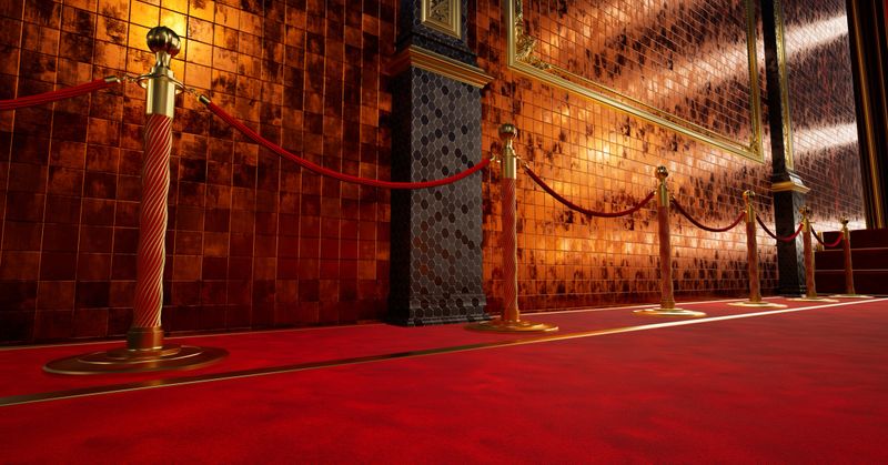 Elegant red carpet entrance with golden stanchions and luxurious wall decor in a glamorous venue setting