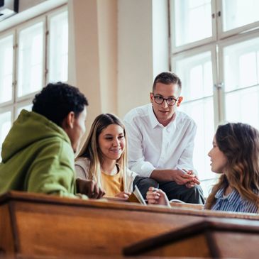Group of students engaged in a discussion in a bright classroom.