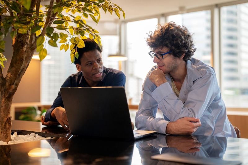 Business development manager presenting data-driven strategies for future-focused decision-making during an informal business meeting in a modern office. The team engages with cloud computing, laptops, and technology to enhance performance and growth in business processes.