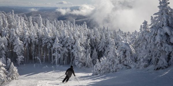 Skier going down a snowy mountain slope.