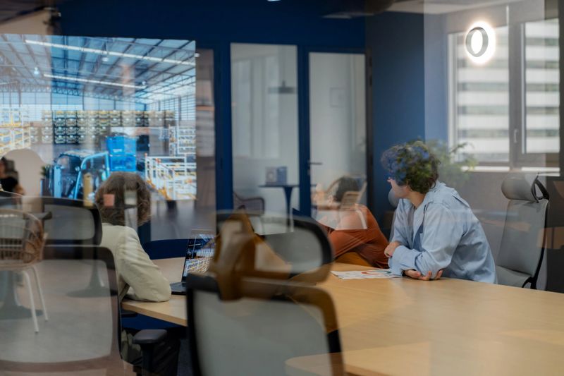 Entrepreneur presenting warehouse logistics solution through video presentation to executives in a modern corporate meeting room. Colleagues engaging in strategy planning, finance, and operational success. Corporate teamwork highlighting leadership and innovation.