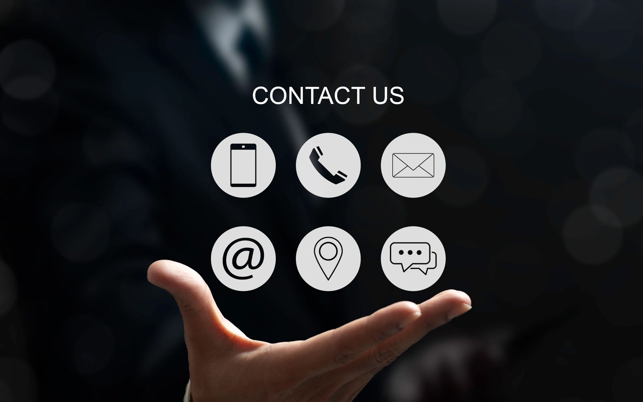 Businessman holding virtual contact icons under the text 'CONTACT US'.