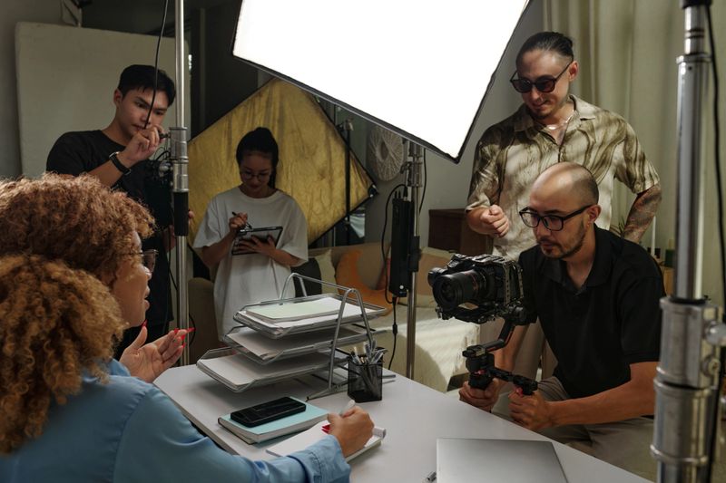 Production group shooting business content with model in studio