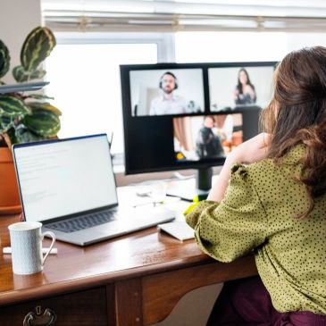Woman attending a video conference from home office.